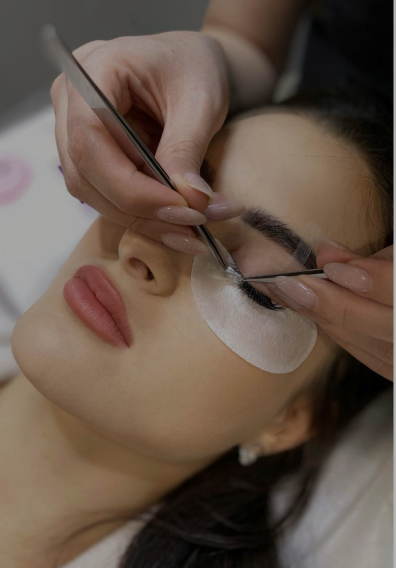Aesthetician applying eyelash extensions to a client at The Lash & Brows Co.