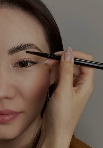 Beautician shaping eyebrows of a client at The Lash & Brows Co.